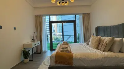 a bedroom with a large bed with a large window at 1BDR with Huge Balcony Stylish Living in Dubai