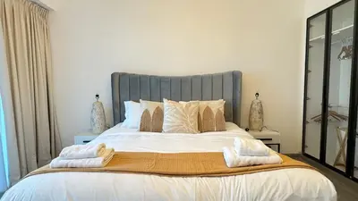 a bedroom with a large bed with towels on it at 1BDR with Huge Balcony Stylish Living in Dubai