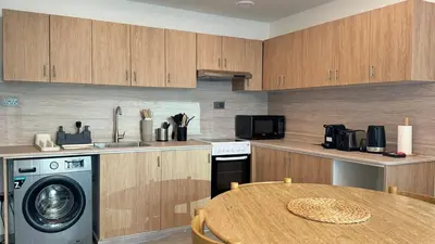 a kitchen with a table and a washing machine at 1BDR with Huge Balcony Stylish Living in Dubai