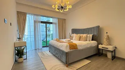 a bedroom with a large bed and a chandelier at 1BDR with Huge Balcony Stylish Living in Dubai