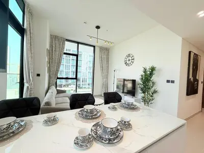 a living room with a table with dishes on it at Binghatti Gardenia 2BHK in JVC in Dubai