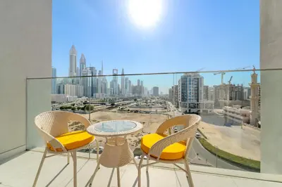 a table and chairs on a balcony with a view of a city at Boutique-Style Luxury Studio in Hyde Walk in Dubai