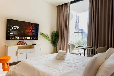 a bedroom with a bed and a tv on the wall at Sleeps 3 Studio JVC I Fully Furnished I Central in Dubai
