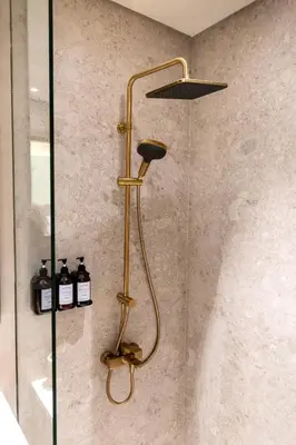 a shower with a brass shower head in a bathroom at Sleeps 3 Studio JVC I Fully Furnished I Central in Dubai