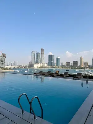 a swimming pool with a city skyline in the background at Ultra Luxury Emaar Beachfront Flat With Private Beach in Dubai