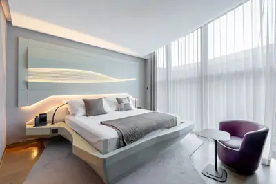 a bedroom with a bed and a purple chair at The Opus Residences 1 Bedroom in Dubai