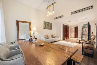 a living room with a wooden table and a couch at Massive 2,000 sqft 1BR with Private Terrace & BBQ in Dubai