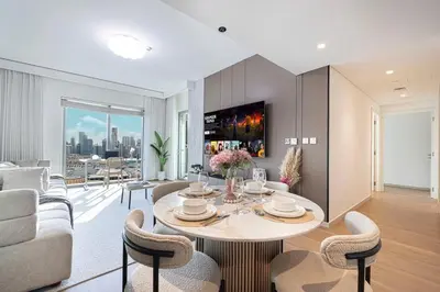 a living room with a table and a couch at Modern 2BR, Burj & Fountains View, Dubai Mall 2 Minutes Walk in Dubai