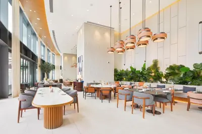 a dining room with tables and chairs and plants at VIDA Marina Best Location NEW in Dubai