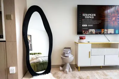 a mirror in a room with a bed and a desk at Modern Studio JVC I Sleeps 3 I Fully Furnished in Dubai