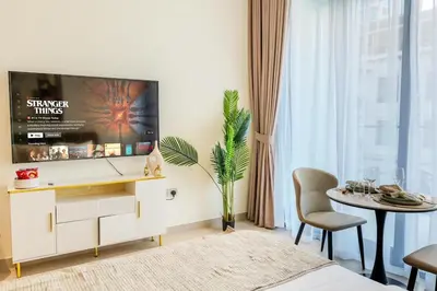 a living room with a tv and a table at Modern Studio JVC I Sleeps 3 I Fully Furnished in Dubai