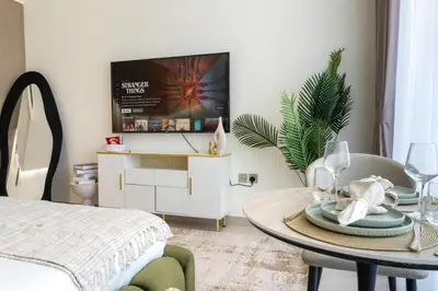 a living room with a table and a tv at Modern Studio JVC I Sleeps 3 I Fully Furnished in Dubai