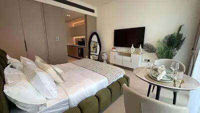 a bedroom with a bed and a table with a television at Modern Studio JVC I Sleeps 3 I Fully Furnished in Dubai