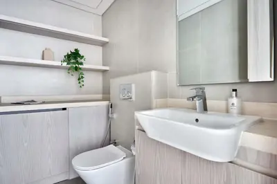 a white bathroom with a sink and a toilet at Frank Porter - Concept Residences in Dubai