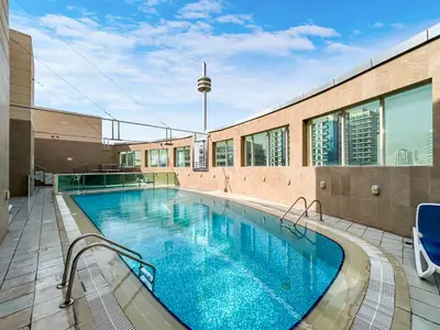 a large swimming pool in front of a building at Elegant Minimal Studio with Balcony in Dubai