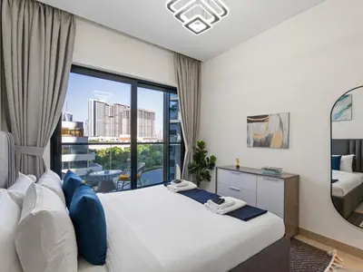 a bedroom with a bed and a large window at Luxury 1BR Featuring Guest - Study Room-SOBHA Waves in Dubai