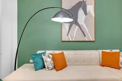 a living room with a white couch with colorful pillows at Stylish 2BR Canal Views, High Floor in Dubai