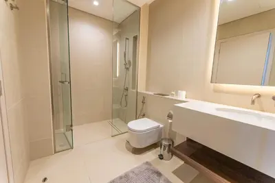 a bathroom with a toilet and a sink and a shower at Exquisite Jumeirah Bay Island Retreat 3 BR plus maids room in Dubai
