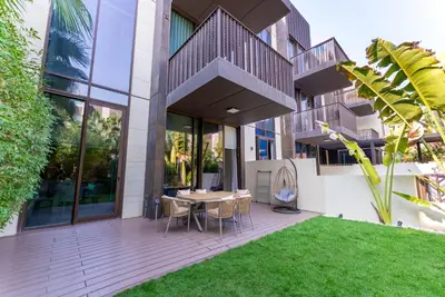 a patio with a table and chairs in front of a building at Exquisite Jumeirah Bay Island Retreat 3 BR plus maids room in Dubai