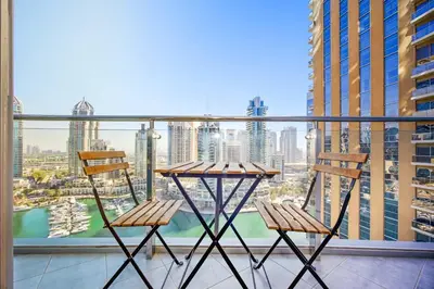 two chairs and a table on a balcony with a view at Stunning 1BR Apartment with Breathtaking Marina Views in Dubai