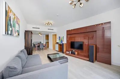 a living room with a couch and a flat screen tv at Stunning 1BR Apartment with Breathtaking Marina Views in Dubai