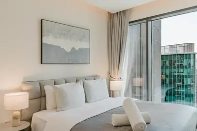 a bedroom with a white bed with a large window at RH- Premium Furnished Living in Business Bay near to Burj Khalifa in Dubai