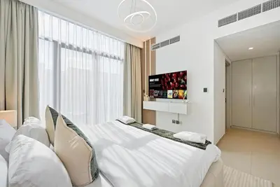 a bedroom with a large white bed and a window at Golden Stays - Tranquil 4BR Villa with Pool & Coastal Charms in Dubai