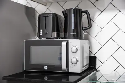 a coffee maker is sitting on top of a microwave at Stylish Bella Rose Stay Pool & Gym in Dubai