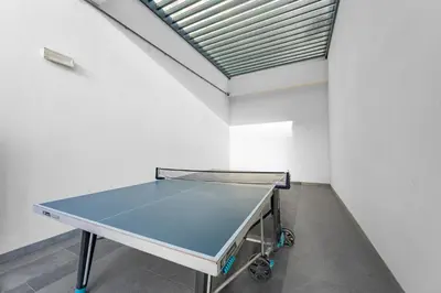 a ping pong table in a room with a ceiling at Stylish Bella Rose Stay Pool & Gym in Dubai