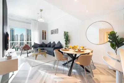 a living room with a couch and a table and chairs at Luxury 1BR Lake View Near Metro & Marina in Dubai