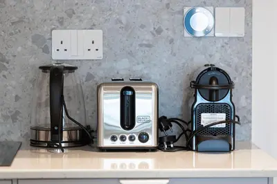 a kitchen counter top with a toaster and a toaster and a toaster at Luxury 1BR Lake View Near Metro & Marina in Dubai