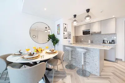 a dining room and kitchen with a table and chairs at Luxury 1BR Lake View Near Metro & Marina in Dubai