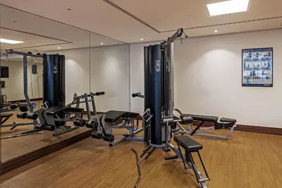 a gym with several treadmills and cardio machines at Luxury 1BR Lake View Near Metro & Marina in Dubai
