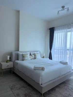 a bedroom with a large bed with a large window at Orchid residence 1BHK apartment in Dubai