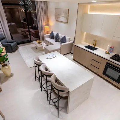 a kitchen and living room with a table and chairs at Brand new apartment with luxury furniture in JVC in Dubai