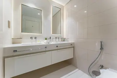 a white bathroom with a sink and a mirror at Panoramic Sea View, Offering Direct Access to Beach, Three Bedrooms and Assistant Room - Beach Vista Tower 2 by Deluxe Holiday Homes in Dubai