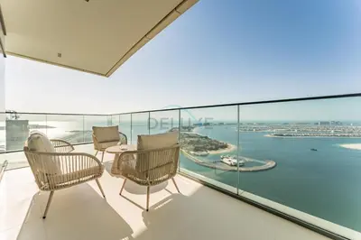 a balcony with chairs and a table and a view of the water at Panoramic Sea View, Offering Direct Access to Beach, Three Bedrooms and Assistant Room - Beach Vista Tower 2 by Deluxe Holiday Homes in Dubai