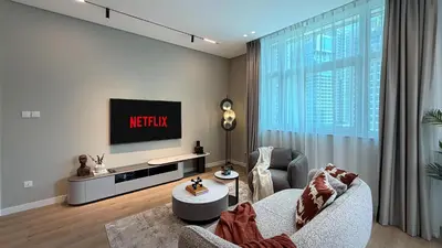 a living room with a television on a wall at Stylish 1 BR with hotel facilities and canal view in Dubai