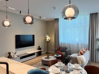 a living room with a flat screen tv on a wall at Stylish 1 BR with hotel facilities and canal view in Dubai
