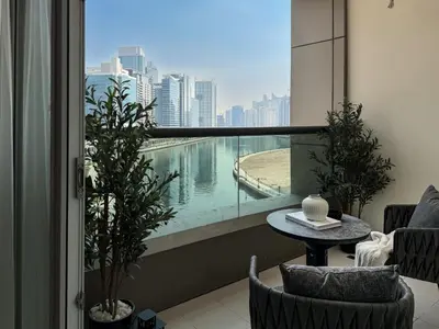 a balcony with a table and a view of a city at Stylish 1 BR with hotel facilities and canal view in Dubai