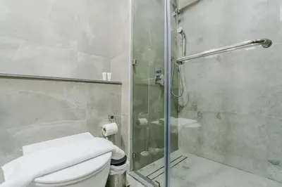 a bathroom with a toilet and a glass shower at RH-Smart Studio Near Expocity & Al Maktoum Airport in Dubai