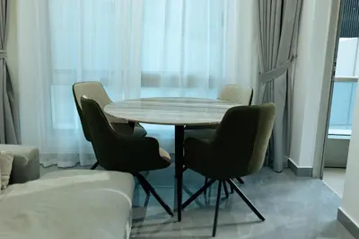 a table and four chairs in a living room at Dubai Marina - 1 BHK Elegant & Modern Apartment in Dubai