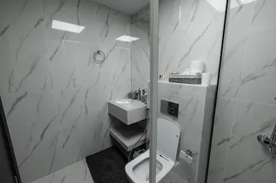 a white bathroom with a toilet and a sink at Dubai Marina - 1 BHK Elegant & Modern Apartment in Dubai