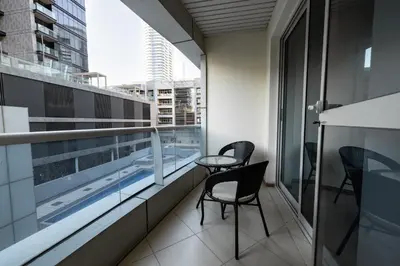a balcony with two chairs and a table on a building at Dubai Marina - 1 BHK Elegant & Modern Apartment in Dubai
