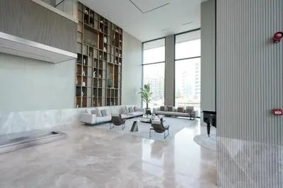 a living room with a couch and a table at Stylish modern studio near Miracle Garden with Gym, Pool and Padel court in Dubai