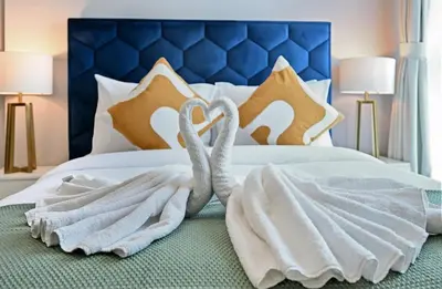 two swans wrapped in towels on a bed at Golden Stays - Opulent 2BR View Residence at The Bay in Dubai
