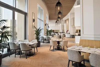 a restaurant with tables and chairs and windows at Highest 1BR in JW Marriott Marina with Marina Views in Dubai
