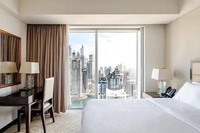 a hotel room with a desk and a large window at Highest 1BR in JW Marriott Marina with Marina Views in Dubai