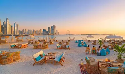 a group of people sitting in chairs on the beach at Seven Palm! Rooftop Infinity Pool with Great View! Private Beach Access! in Dubai