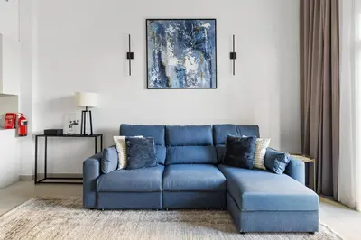 a blue couch sitting in a living room at Modern 1BR in Jadeel 2 MJL in Low Floor in Dubai